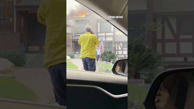 Man rescues American flag from stranger's yard as home burns behind him