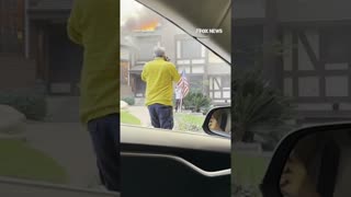Man rescues American flag from stranger's yard as home burns behind him