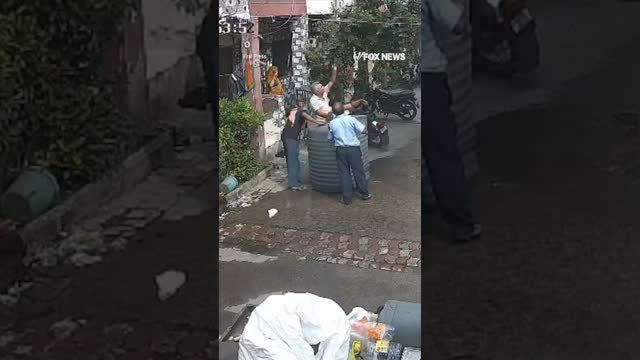 Woman miraculously escapes unharmed after a fallen water tank lands perfectly around her